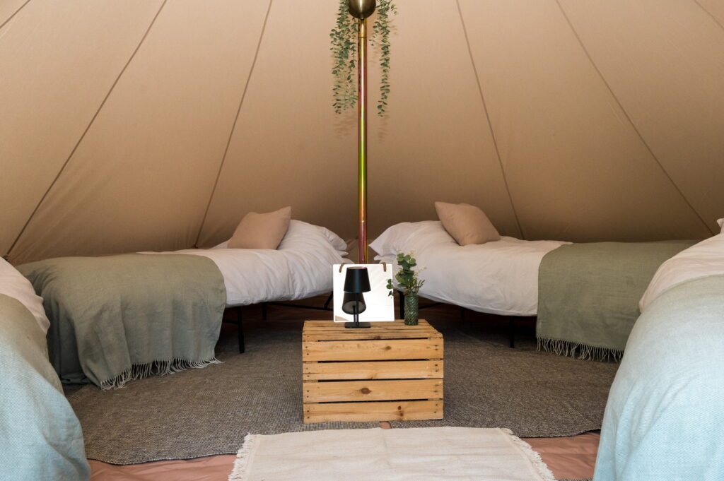 Festival bell tent interior with four single beds made up